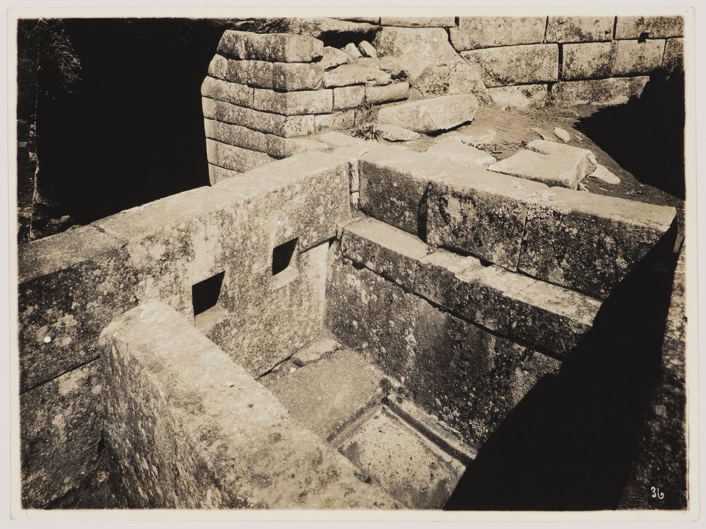 View of the principal liturgical bath with the lower portion of the Serpent Gate in the background, Machu Picchu, Peru