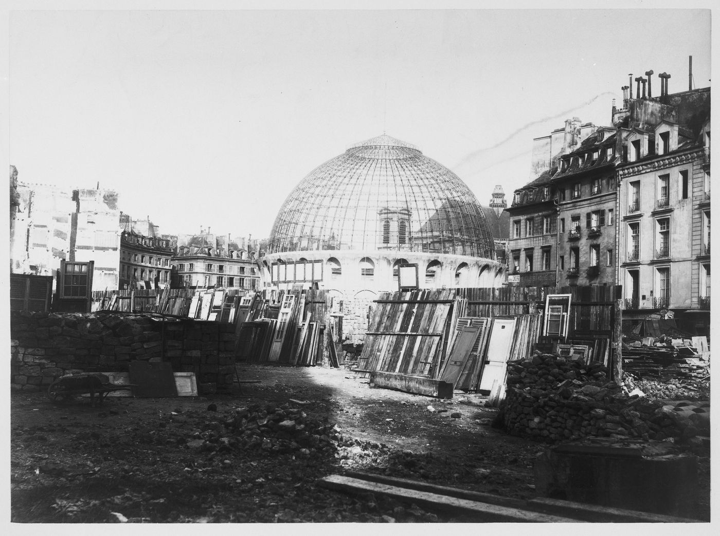 Corn Exchange, domes structure in a street surrounded by bricks, rubble, fences, and stacks of old doors, Paris, France