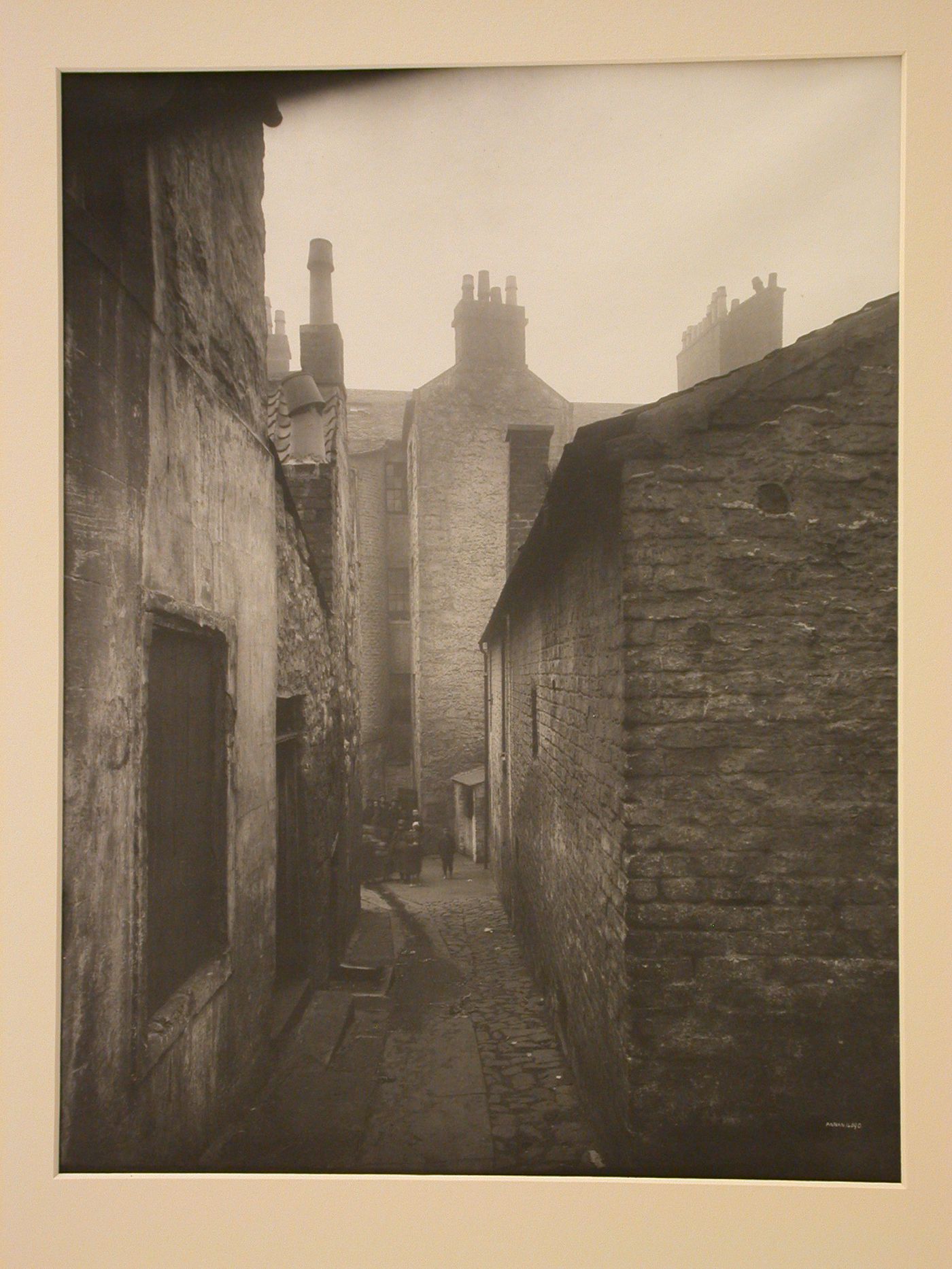 View of a narrow alley with a crowd of children standing at the end, Glasgow, Scotland