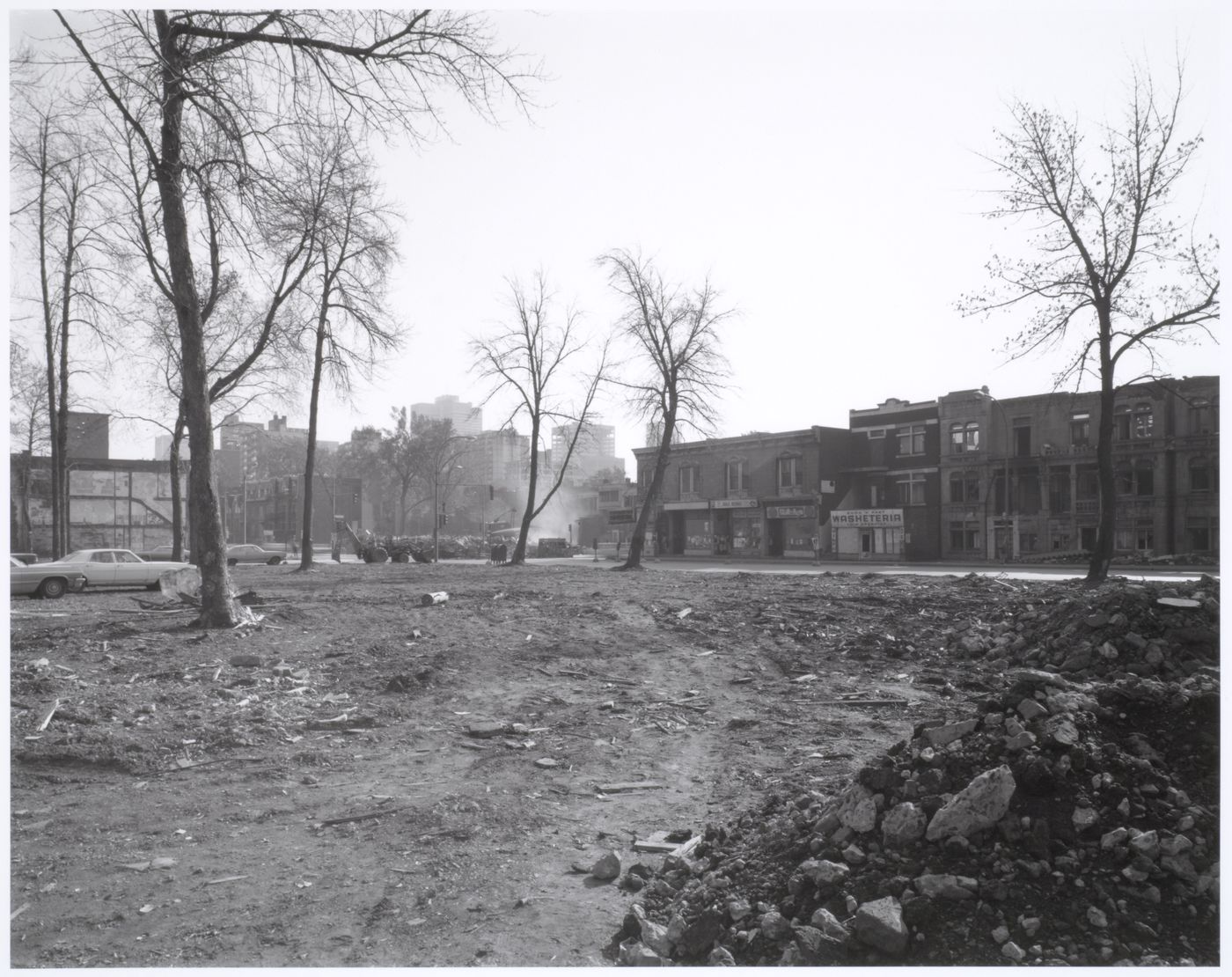 View of the Milton-Parc neighbourhood showing an empty lot in the foreground and the demolition of a building in the background, corner of avenue du Parc and rue Prince-Arthur, Montréal, Québec