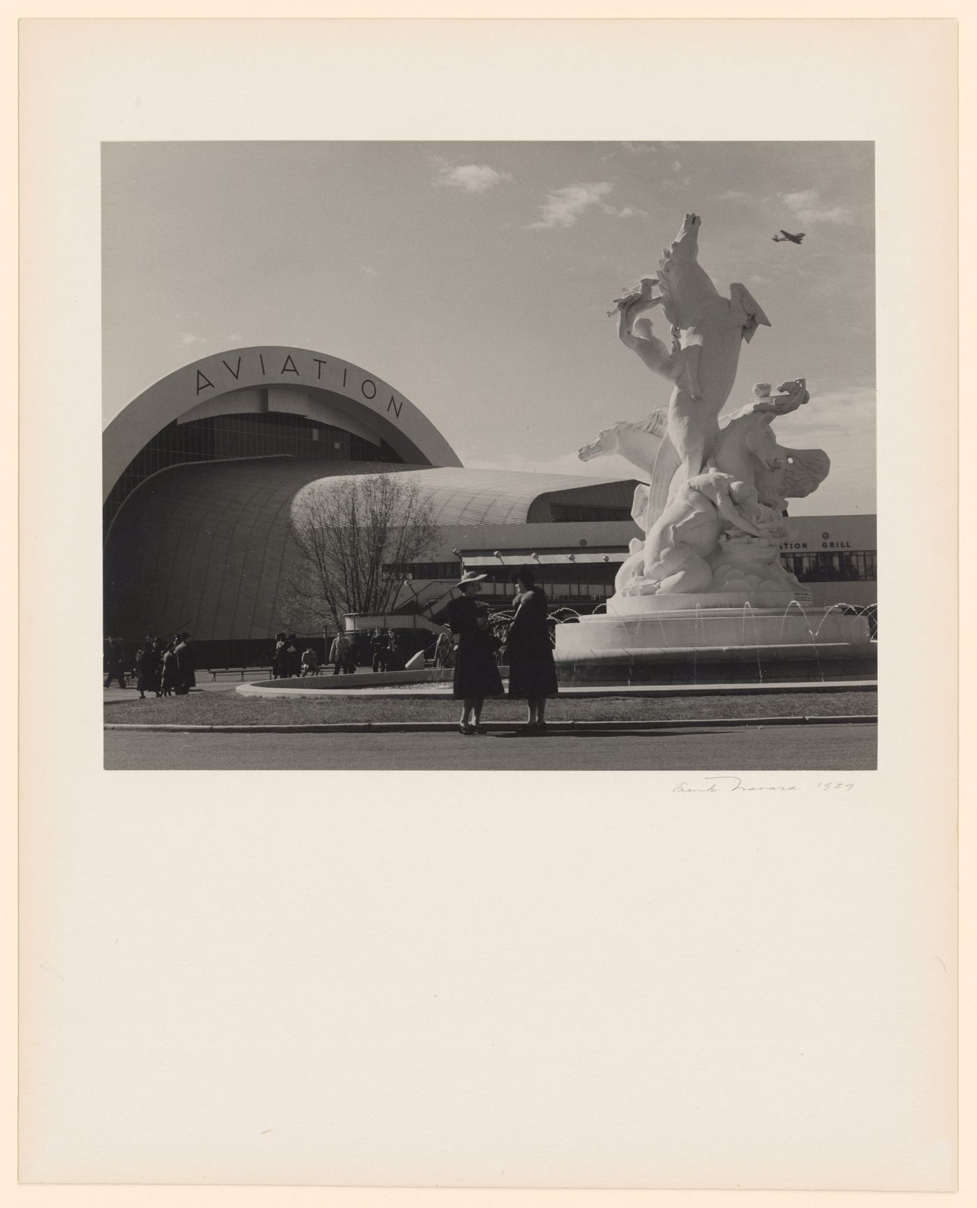 New York World's Fair (1939-1940): 3/4 view of Aviation Building, visitors and sculpture in foreground