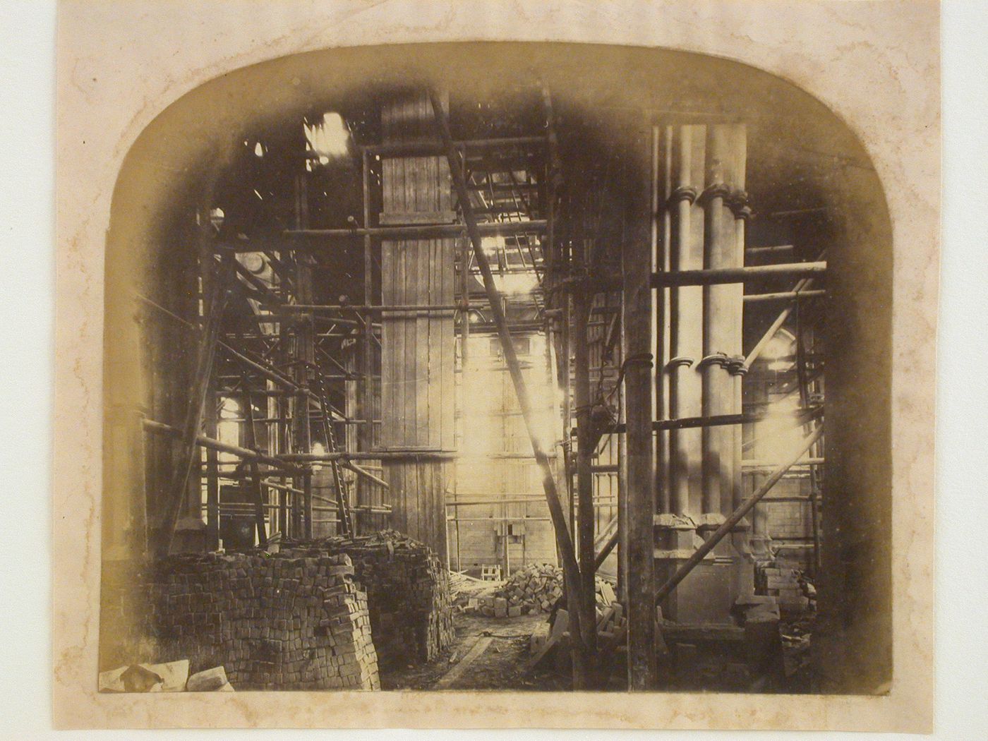 Interior view of the Church of St. Philip Neri (now the Cathedral of Our Lady and St. Philip Howard) under construction, prior to the construction of the floor and showing scaffolds and construction materials, Arundel, West Sussex, England
