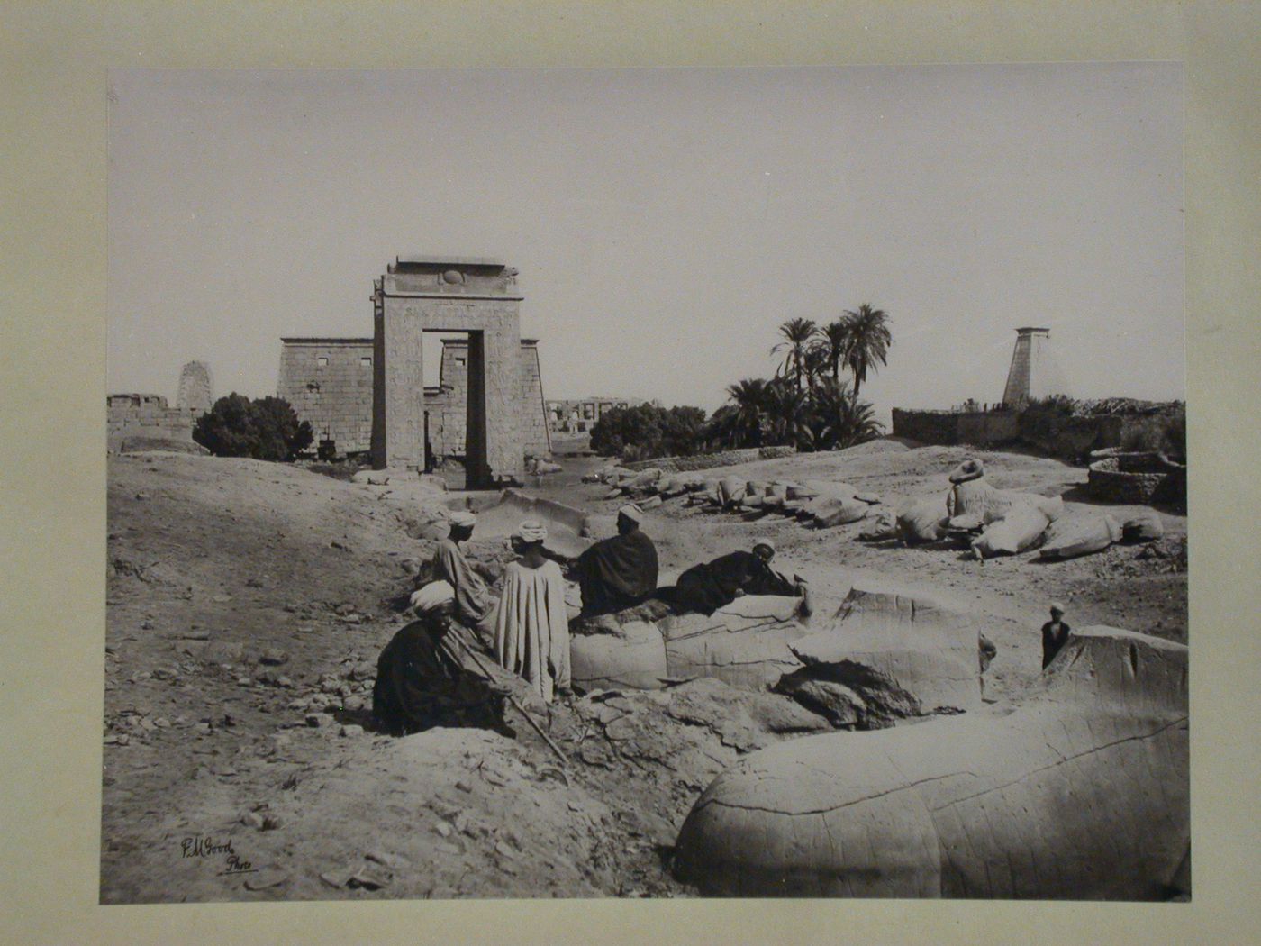 View of Avenue of the Sphinxes, the Southern Gate of Ptomely III, Euergetes I and temples of Khonsu behind, with people resting in the foreground, Karnak, Thebes, Egypt