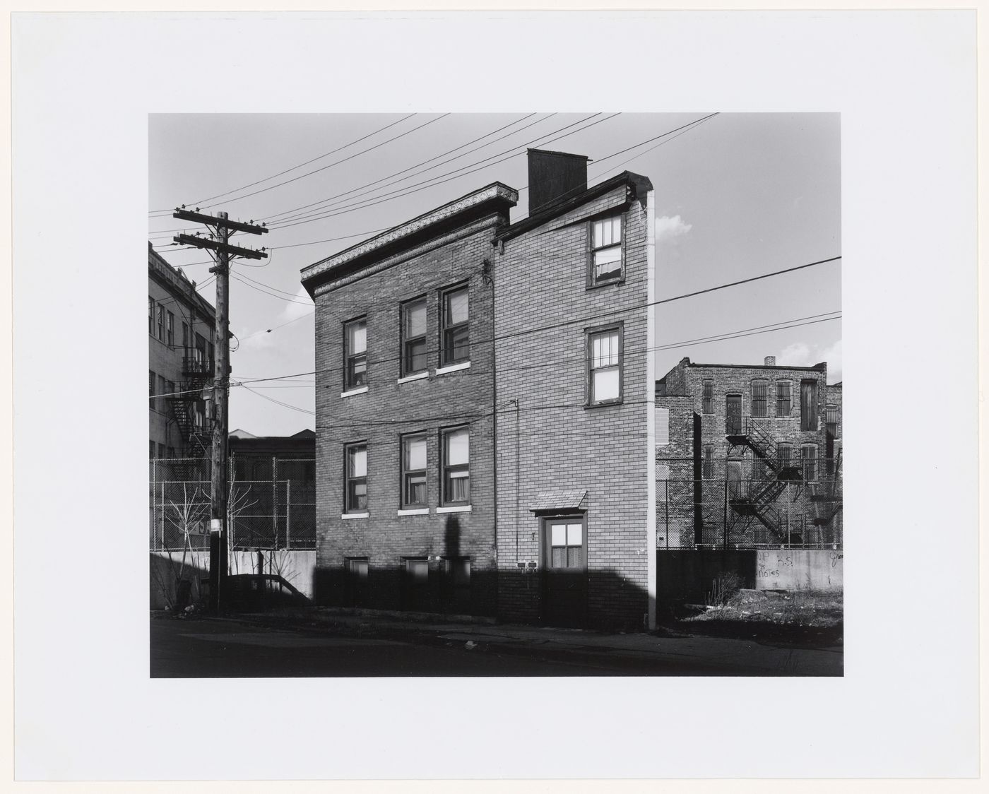 View of an apartment house with fences, walls and apartment houses in the background, Chicago, Illinois, United States